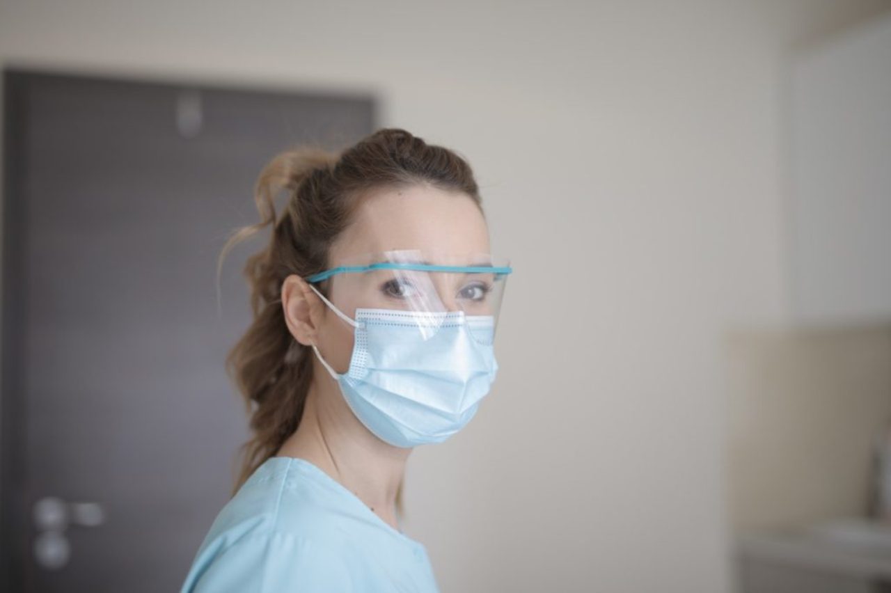 femme en chemise bleue portant un masque