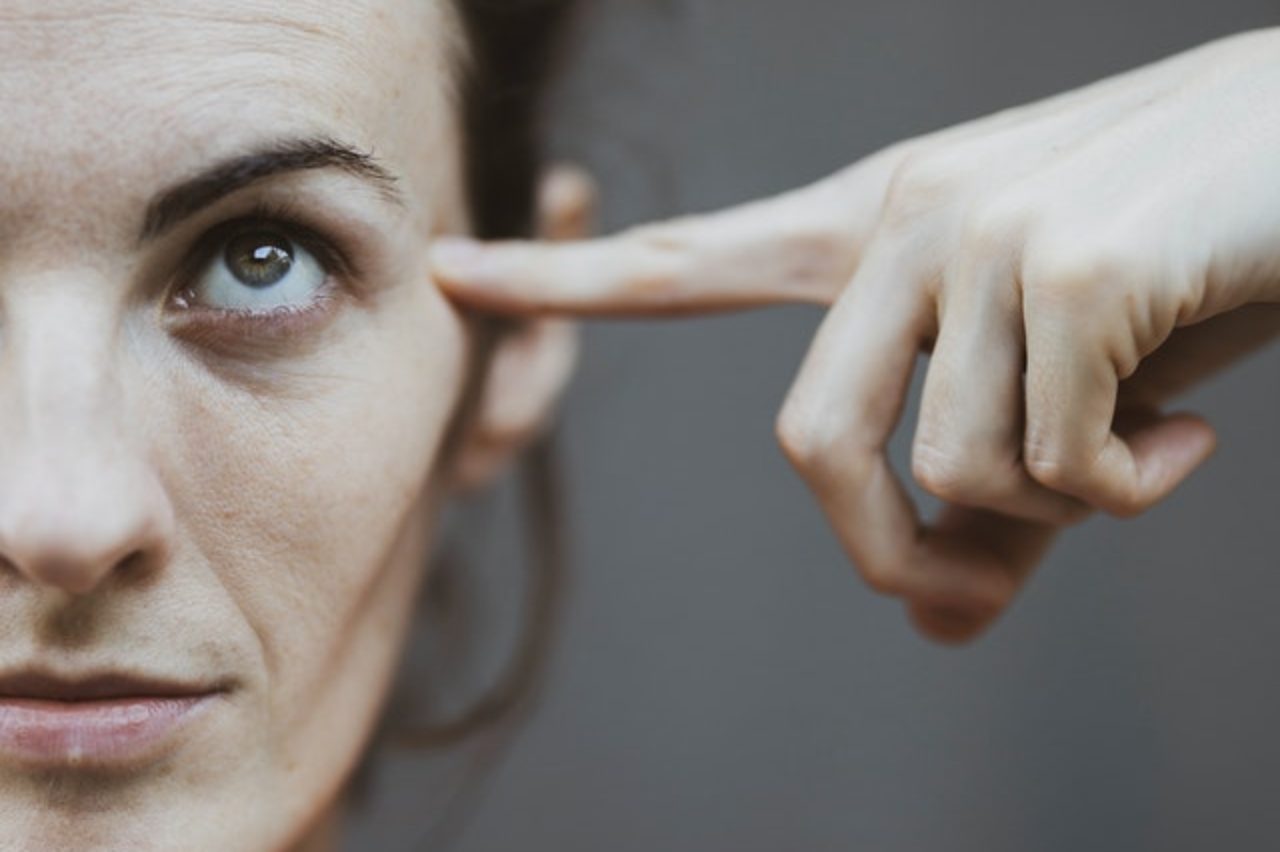 photo / selective-focus-portrait-photo-de-femme-en-rouge-t-shirt-pointant-vers-sa-tete