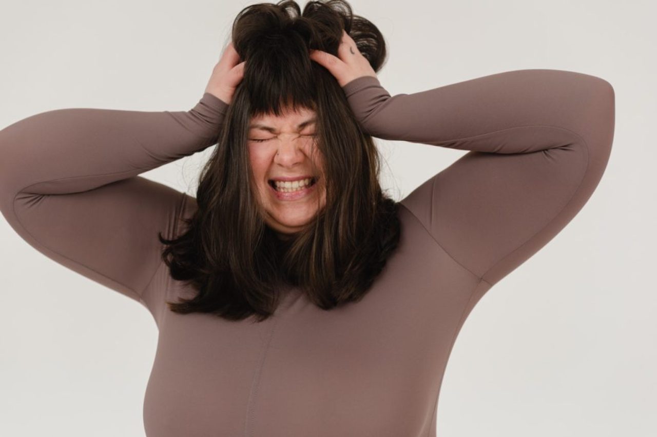 jeune femme obèse, cheveux froissés, yeux fermés, dans un studio blanc